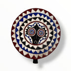 Bwa African sun mask with blue, red and black tones in a plain background