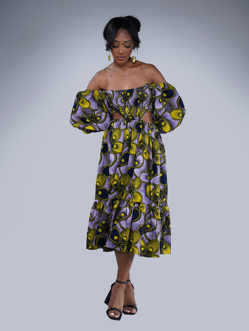 Brown girl wearing a purple and yellow cut out midi dress