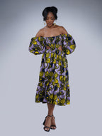 Brown girl wearing a purple and yellow cut out midi dress
