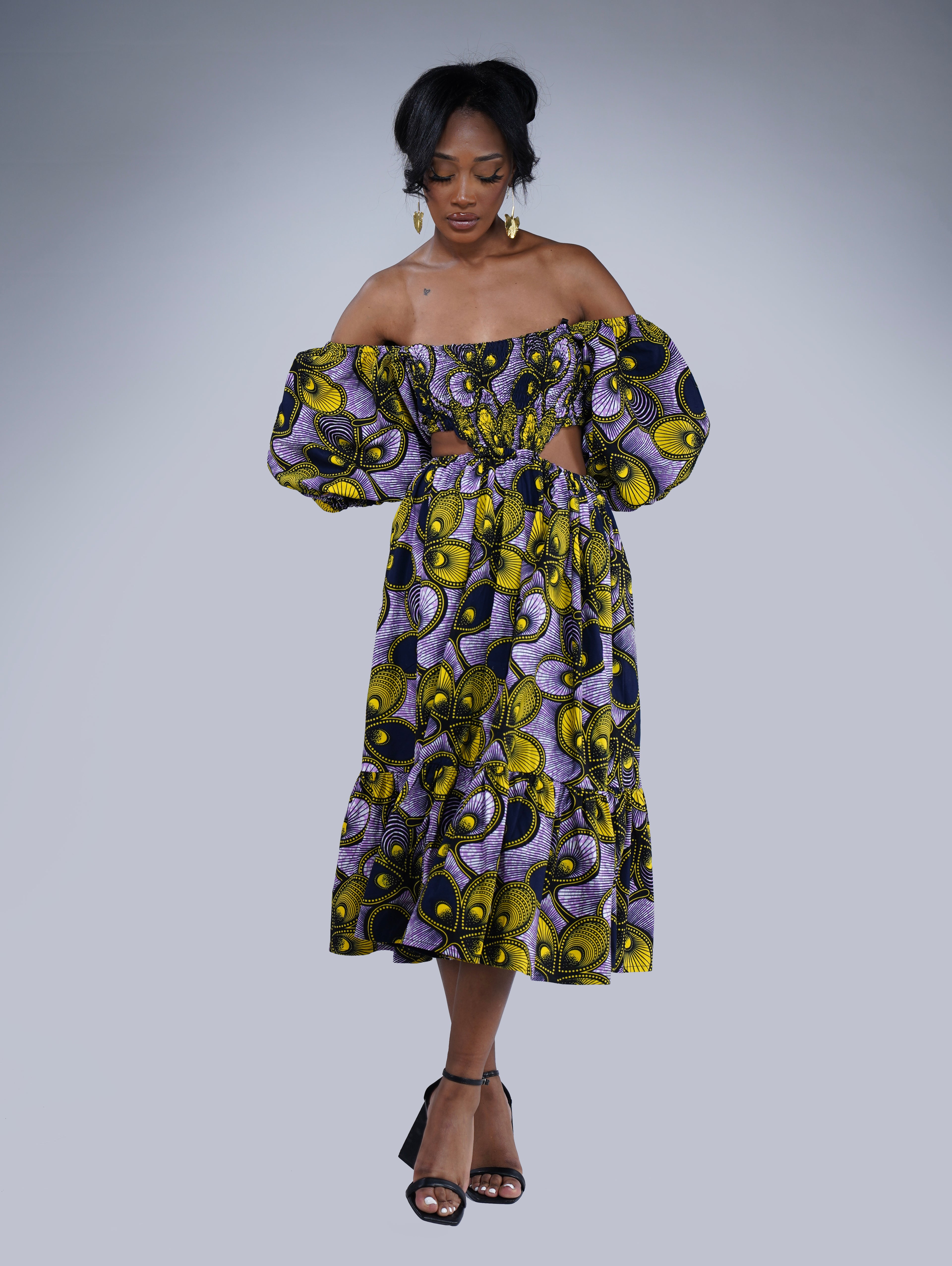 Brown girl wearing a purple and yellow cut out midi dress