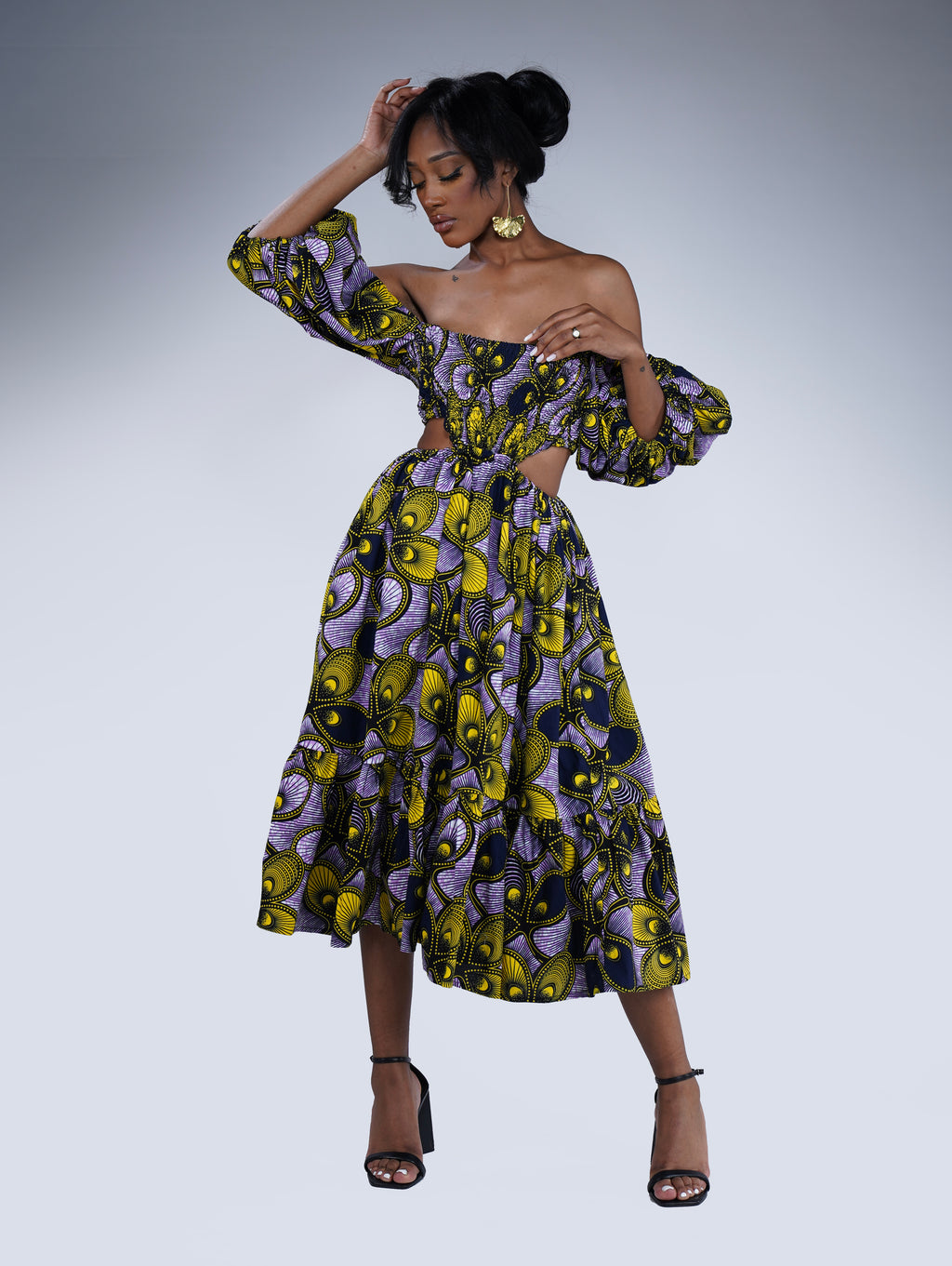 Brown girl wearing a purple and yellow cut out midi dress