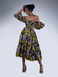 Brown girl wearing a purple and yellow cut out midi dress