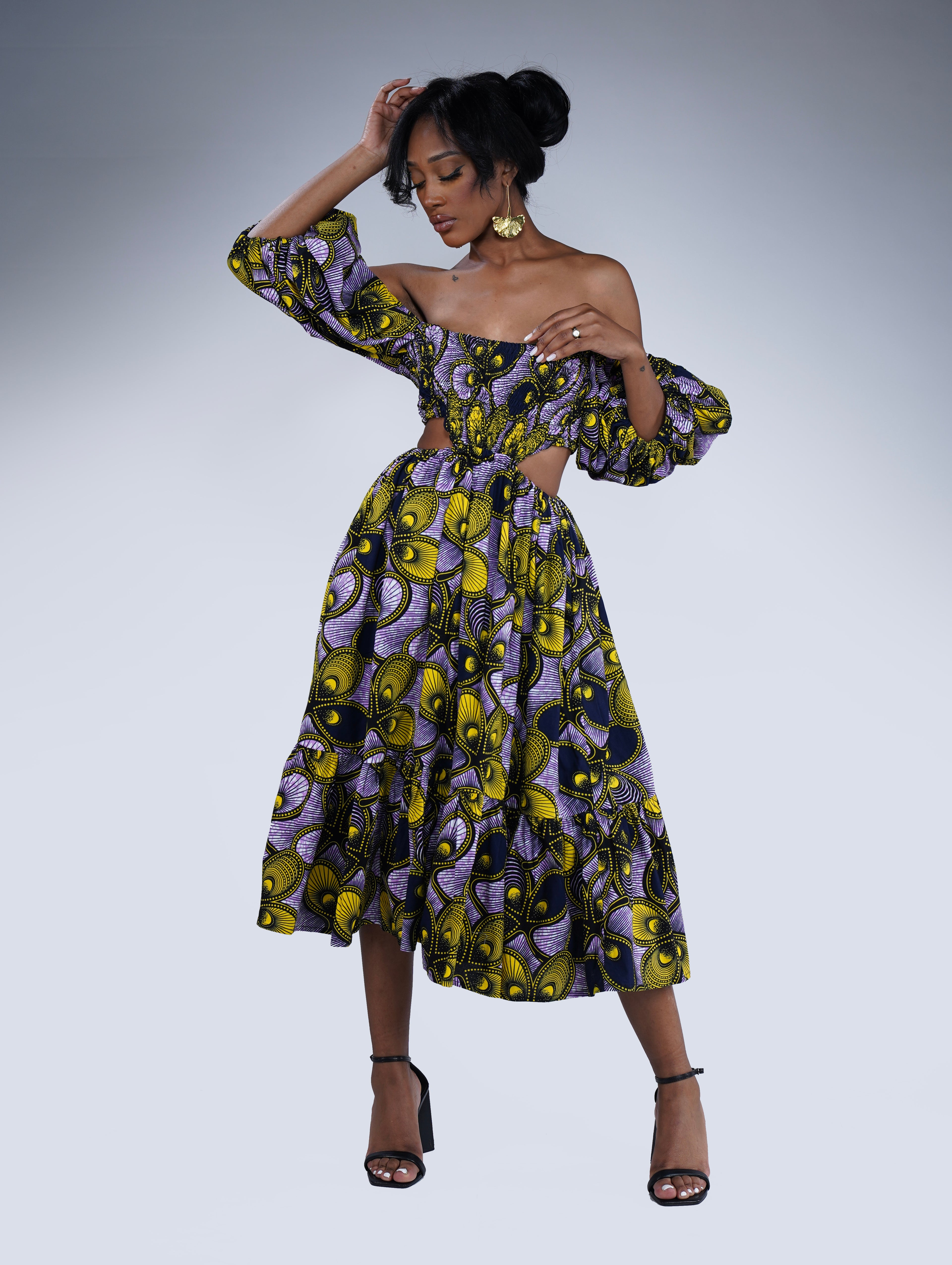 Brown girl wearing a purple and yellow cut out midi dress